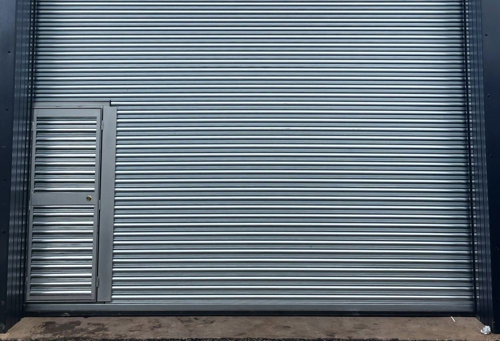 Wicket gate sset into roller-shutter in industrial building